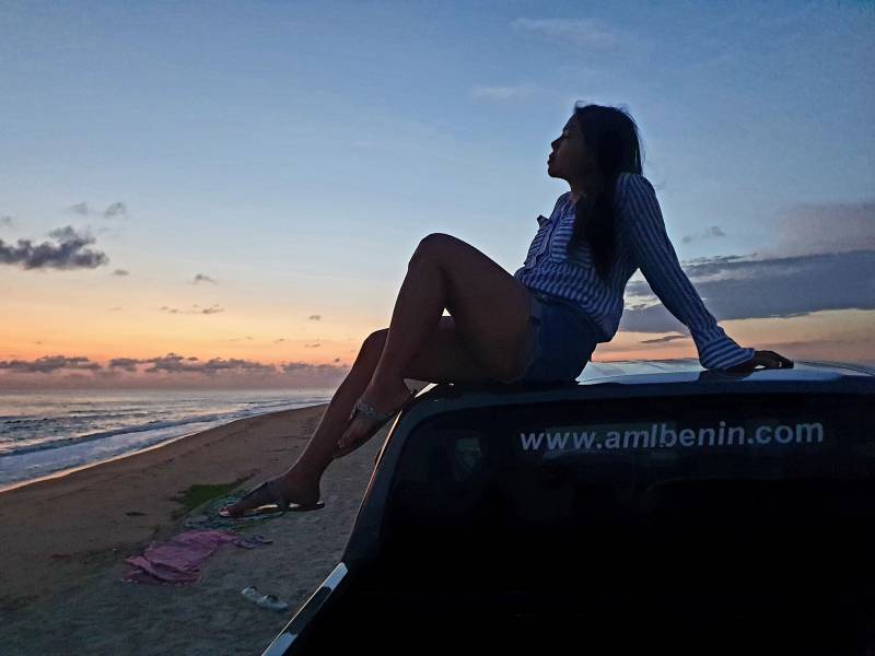 Cliente profitant du couché soleil sur la plage